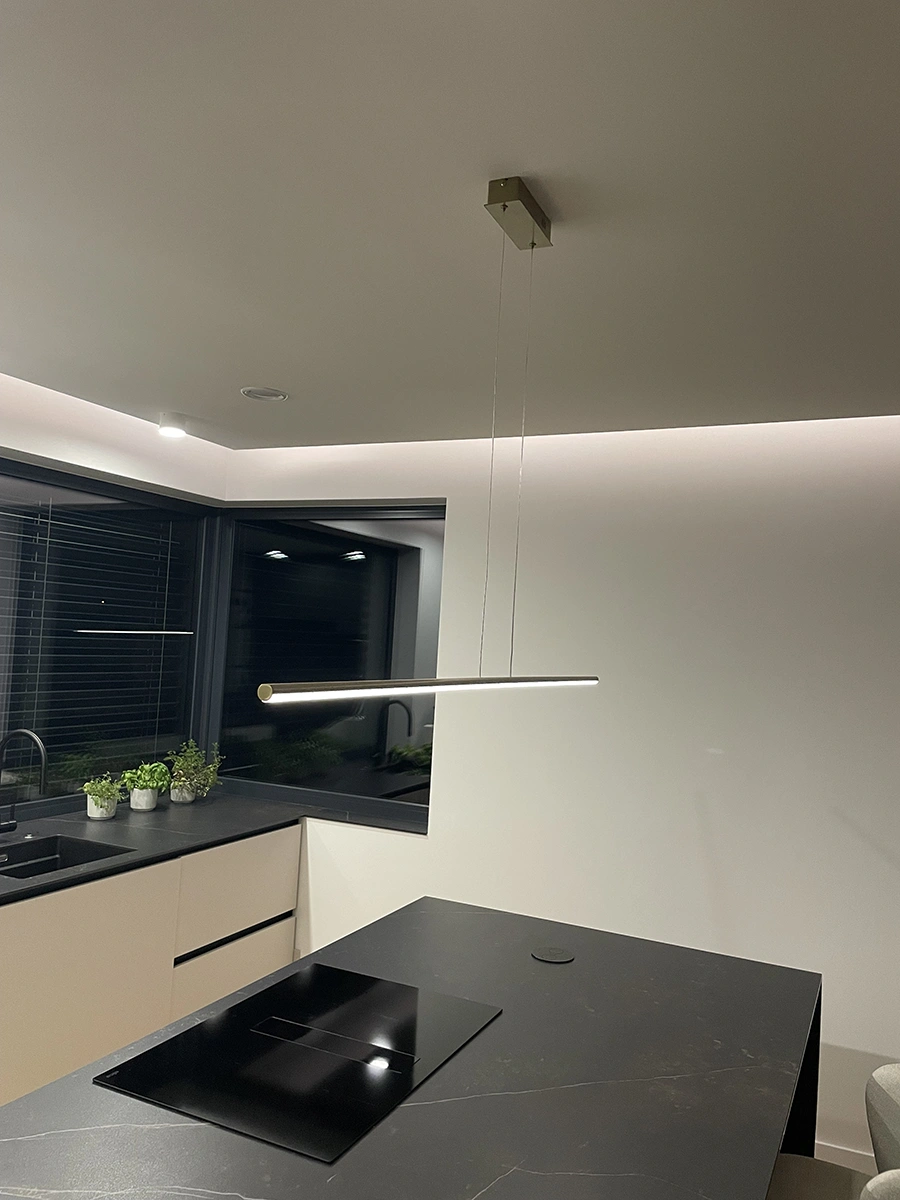 Goldene LED Linienleuchte Led Line 150 cm über Kücheninsel in dunkler Einrichtung, 3000K warmweiß