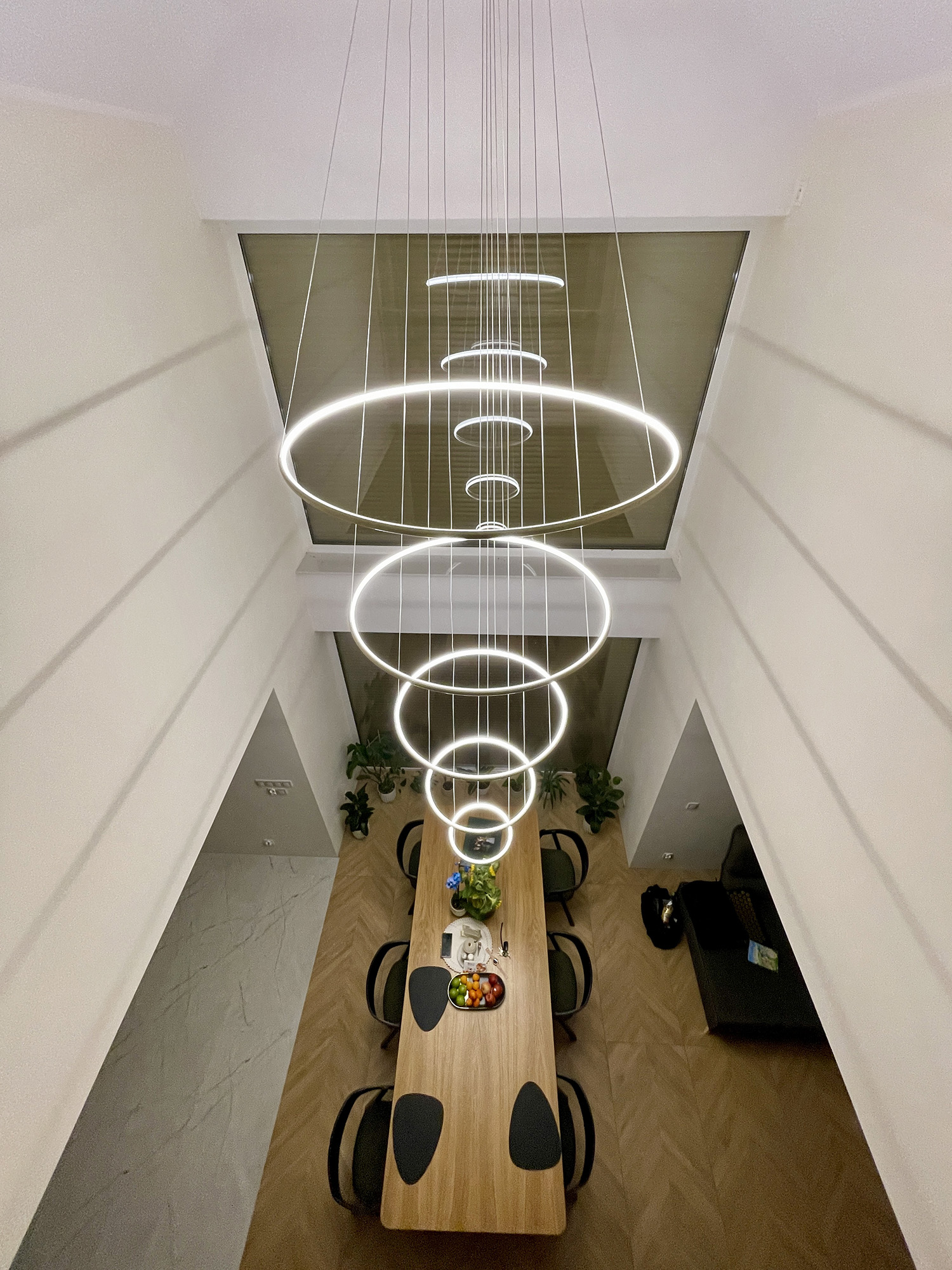 Großer LED Kronleuchter Led Orbit No.5 in einem Wohnzimmer mit Galerie und hoher Decke